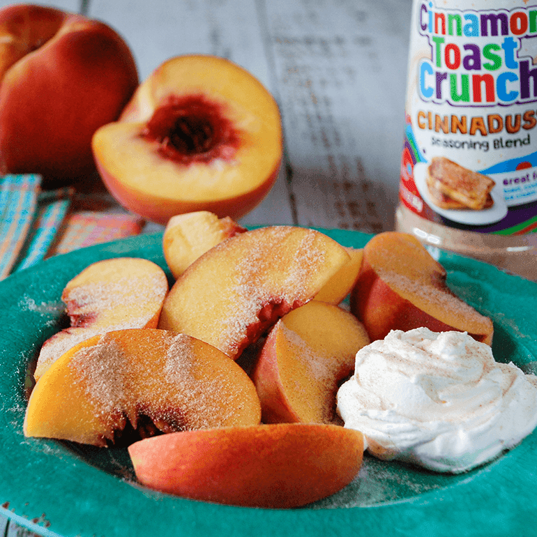 A bowl of Cinnadust™ Peaches and Cream with Cinnadust™ on the peaches and a jar of it behind.