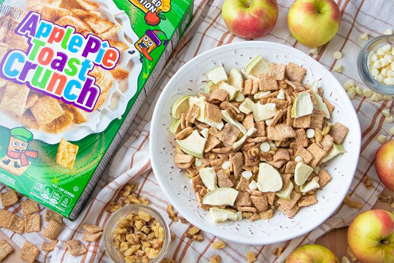 A bowl of Apple Pie Toast Crunch™ Cereal with apples surrounding the bowl.